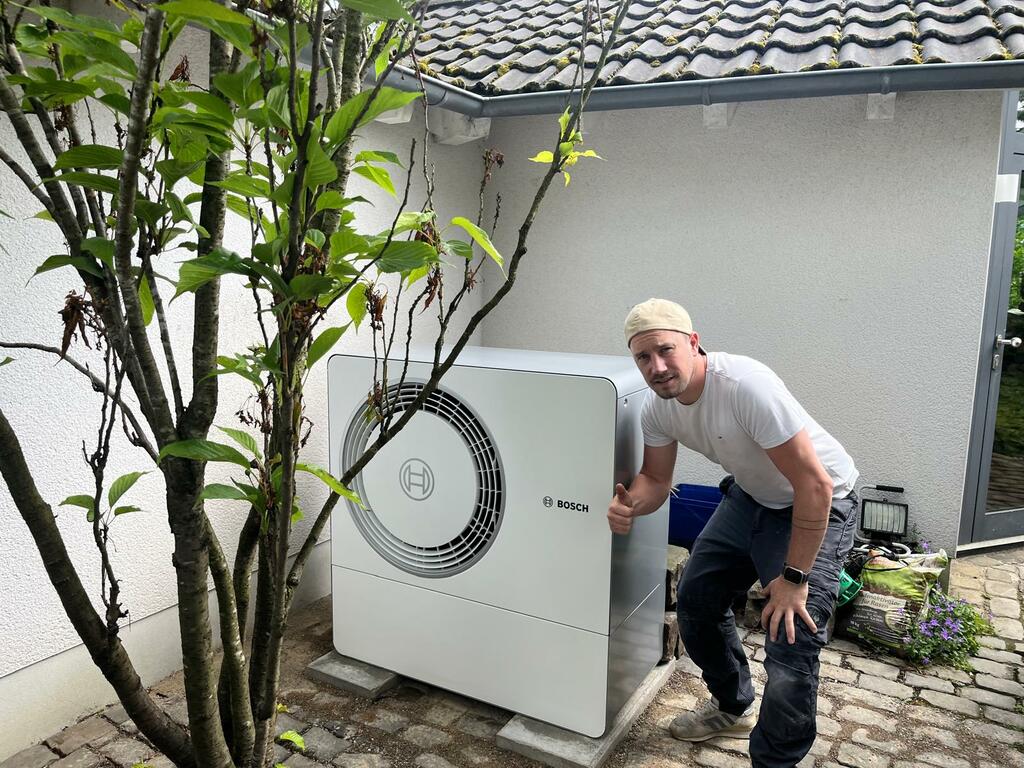 Robin Graefe neben einer installierten Bosch Wärmepumpe
